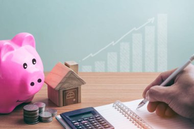 House sikkeleri üzerinde yerleştirilen ve kumbara erkekler el tasarruf para sikke ev concept konsept Emlak merdiven, ipotek ve gayrimenkul yatırım için satın almak için planlama. kaydetme veya yatırım fo