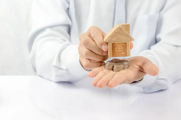 House placed on coins Men's hand is planning savings money of co