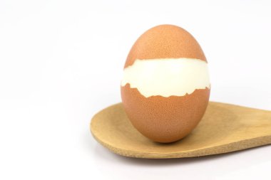Tahta kaşık üzerine yerleştirilen haşlanmış yumurta, beyaz arka plan