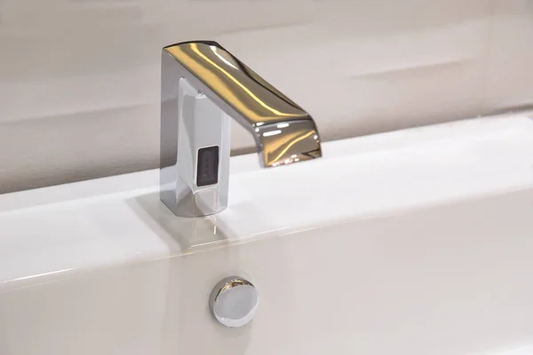 Кран в ванной комнате полированный хромированный автоматический с помощью датчика . — стоковое фото