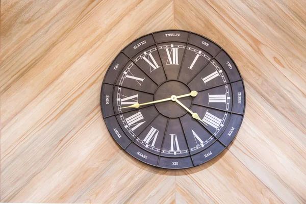 Czarno-biały zegar pokazany na jasnym drewnianym ścianie , — Zdjęcie stockowe