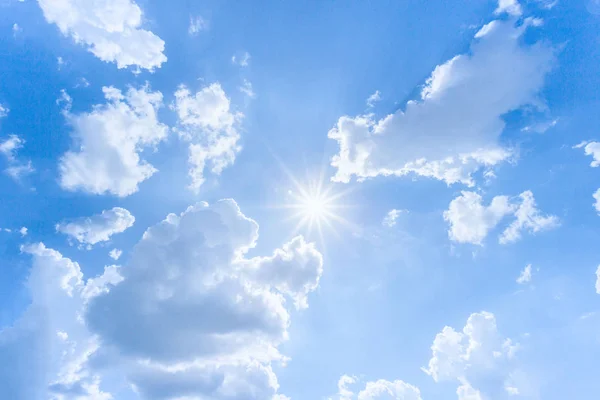 Fundo ensolarado, céu azul com nuvens brancas e sol. — Fotografia de Stock