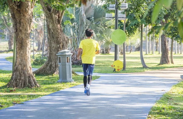 Sporty homem jogging ou exercício no parque sombrio no início morni — Fotografia de Stock