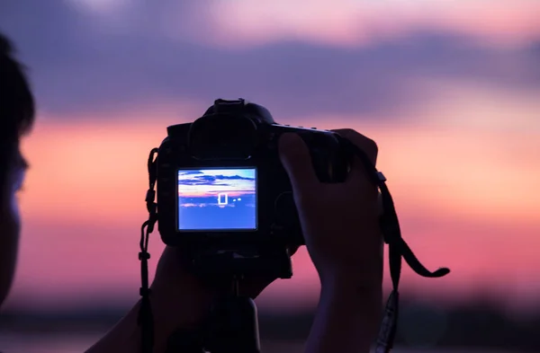 Genç fotoğrafçı ve refleks kamera gölün yanındaki tripoda., — Stok fotoğraf
