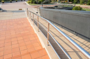Paslanmaz çelik tırabzan ile beton rampa yolu engelli insanları desteklemek için engelli.