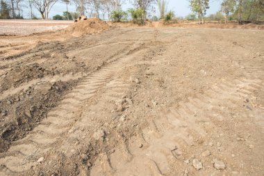 Kuru, çatlak bataklık ıslah toprağı, konut inşaatı için arazi arazi, kırsal alanda araba lastiği izi ve temiz hava ile güzel mavi gökyüzü. Satış arazisi konsepti için arazi.
