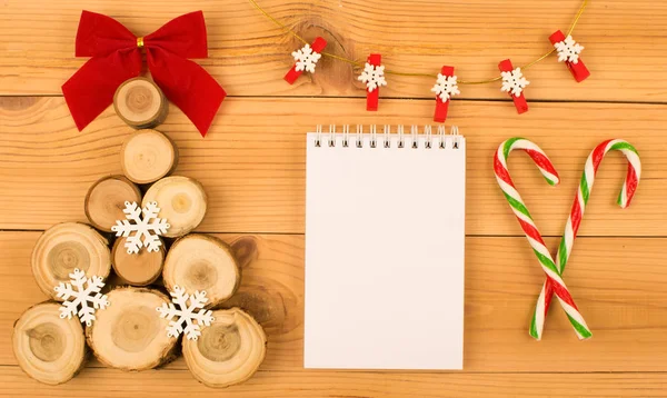 Bir Noel ağacı ahşap kesim bir kırmızı yay ve beyaz kar taneleri ile yapılmış. Bunun yanında istek ve iki karamelli köpekler kırmızı-yeşil renk yazmak için beyaz bir dizüstü bilgisayardır. Yukarıda da çelenk kar taneleri ile olduğunu. Her şey bir ahşap arka plan üzerinde olduğunu.