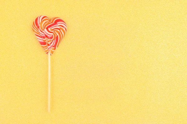 Lolipop altın arka plan üzerinde kalp şeklinde.