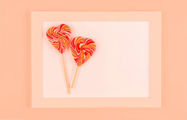 Lolipop beyaz bir çerçeve içinde. Mercan arka plan.