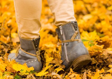 Kadın ayak sonbahar yere yürüyüş yakın çekim.