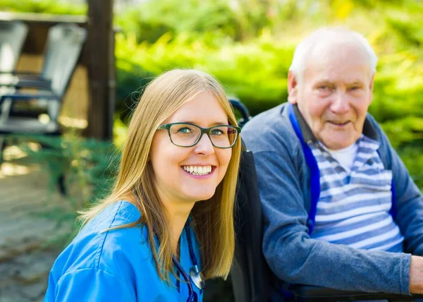 Porträtt Förlamad Äldre Man Vårdare Vårdhem Trädgård — Stockfoto