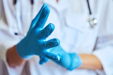 Doktor lastik eldiven üzerinde koyar