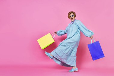 Alışveriş ile Funky yaşlı kadın, Shopaholic kadın, giysi satın aldı,