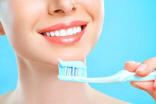 Portret van aantrekkelijke blanke lachende vrouw geïsoleerd op witte studio schot poetsen haar tanden — Stockfoto