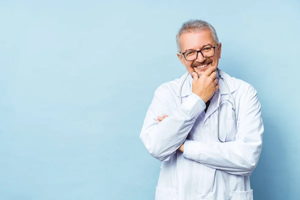 Cheerful mature doctor posing and smiling at camera, healthcare and medicine.