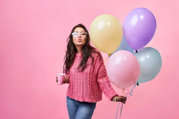 Glad ung leende kvinna med ballonger i handen, på en rosa bakgrund — Stockfoto