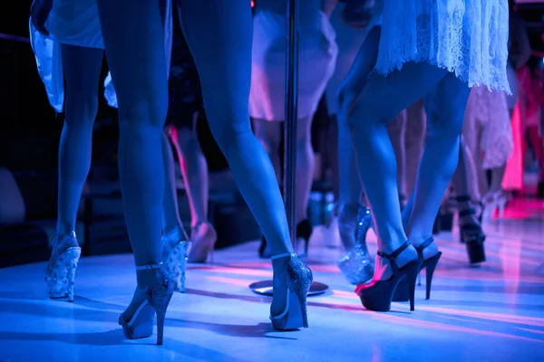 Jeune femme sexy strip-tease pole dance avec pylône en boîte de nuit. Belle strip-teaseuse nue sur scène. Belles jambes féminines en bandes de chaussures à talons hauts — Photo