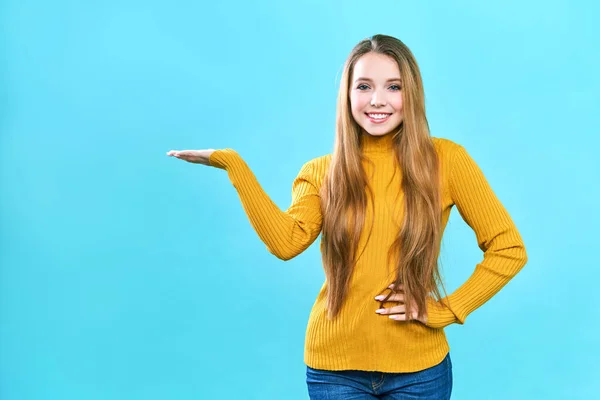 Retrato alegre joven bonita dama de pie aislado sobre fondo azul. Mirando cámara que muestra copyspace —  Fotos de Stock