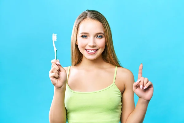 젊은 아름다운 여자는 치아를 청소에 종사하고있다. 아름 다운 미소 건강 한 흰색 치아입니다. 한 소녀가 칫솔을 들고 있다. 구강 위생의 개념. 치과 진료, 치과 진료소 홍보 이미지 — 스톡 사진