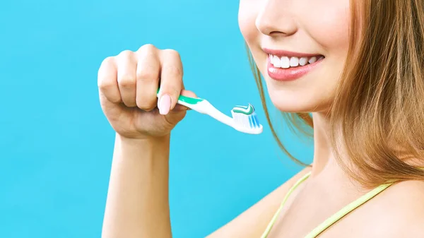Jonge mooie vrouw is bezig met het schoonmaken van tanden. Mooie glimlach gezonde witte tanden. Een meisje houdt een tandenborstel. Het concept van mondhygiëne. Promotionele afbeelding voor een stomatologie, tandheelkundige kliniek — Stockfoto
