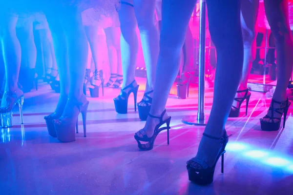 Jonge sexy vrouw paaldansen striptease met pyloon in nachtclub. Mooi naakt stripper meisje op het podium. Mooie vrouwelijke benen in hoge hakken schoenen strips — Stockfoto