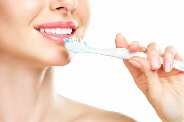 Joven hermosa mujer se dedica a la limpieza de dientes. Hermosa sonrisa dientes blancos sanos. Una chica sostiene un cepillo de dientes. El concepto de higiene bucal. Imagen promocional para una estomatología, clínica dental — Foto de Stock