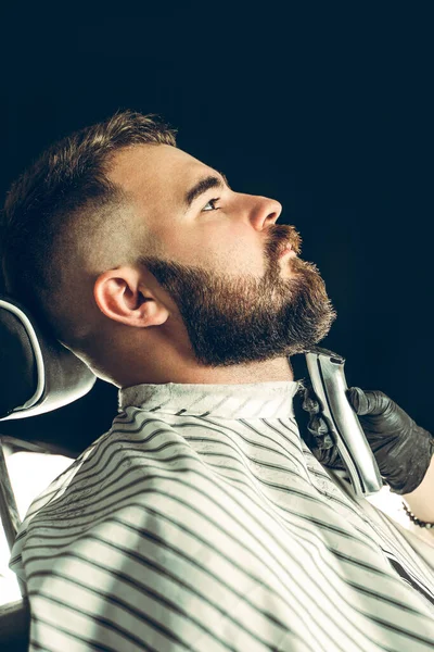 Un client de salon de coiffure. Homme se faire tailler la barbe avec un rasoir électrique — Photo