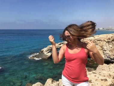 popüler bir yer Kıbrıs sahil kıyısında pembe bir t-shirt açık tenli genç kadın