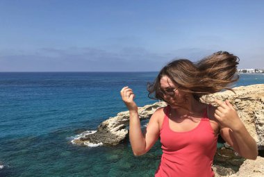popüler bir yer Kıbrıs sahil kıyısında pembe bir t-shirt açık tenli genç kadın