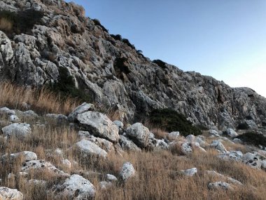 güneş doğar ve arkadan dağlar, deniz, kıyı şeridi ufukta bir boğucu yaz günü planlanmaktadır görülür