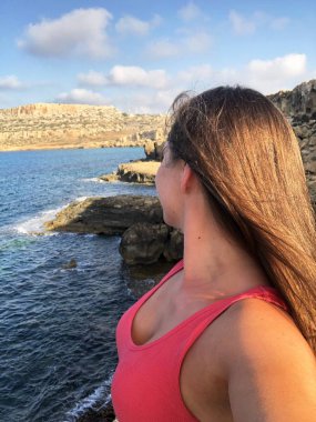 popüler bir yer Kıbrıs sahil kıyısında pembe bir t-shirt açık tenli genç kadın