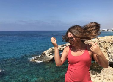 popüler bir yer Kıbrıs sahil kıyısında pembe bir t-shirt açık tenli genç kadın