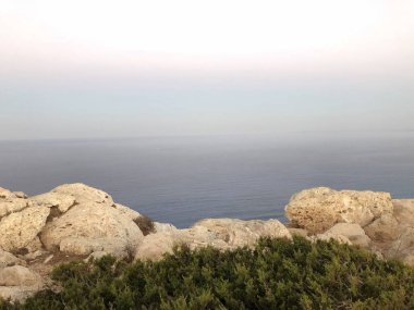 güneş doğar ve arkadan dağlar, deniz, kıyı şeridi ufukta bir boğucu yaz günü planlanmaktadır görülür