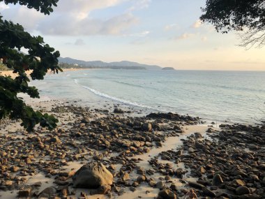 yemyeşil bitki örtüsü ve ulusal Thai house ile vahşi plaja erken günbatımında tepeden görüntülemek