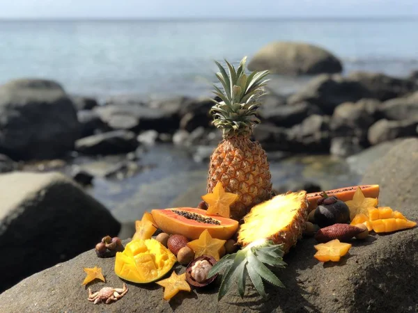 Saftige frische thailändische Früchte Mango, Ananas, Mangostan, Papaya auf einem Stein gegen das Meer und bewölkten blauen Himmel am Nachmittag — Stockfoto