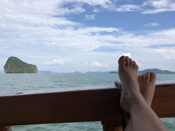 Pés de uma menina de pele clara a bordo de um navio em um dia quente de verão contra o mar da Tailândia, Phuket, relaxar e desfrutar da vida — Fotografia de Stock