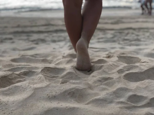 Сексуальные женские загорелые ноги на белом мелком песке уникального пляжа Карон Пхукета на фоне моря и Золотого заката, ощущение удовольствия и гармонии — стоковое фото
