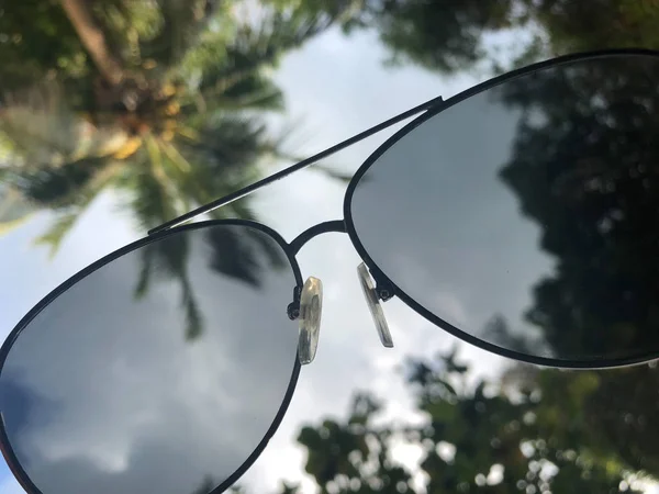 Widok przez okulary przeciwsłoneczne na południowe niebo i palmy, poczucie odpoczynku i relaksu — Zdjęcie stockowe