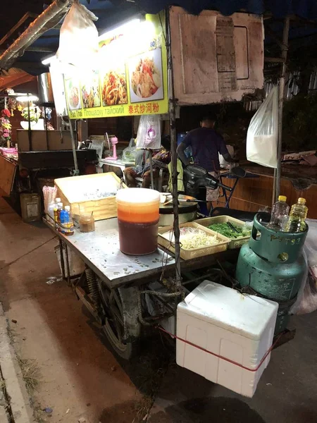 タイの国民料理: モバイル小さなキッチンの男の通りには、魚介類で麺を準備します — ストック写真