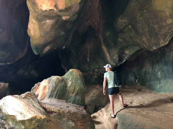 light-skinned guy in beach clothes on the background of hanging unique rocks of the island of Thailand on a clear day