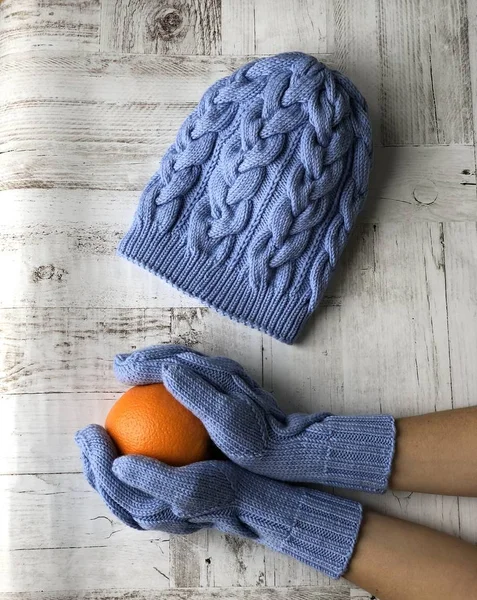 blue hand-knitted set: hat, mittens, scarf with orange, dry and wild rose berries, almonds, herbs.