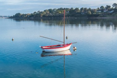     Kayık, beyaz ve kırmızı tekne ve arka planda Morbihan Körfezi ile Brittany, cam gibi bir denizde şamandıralar 