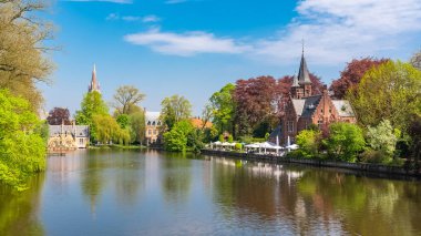 Bruges Belçika, kanal ve arka planda bir kilise güzel tipik evler 