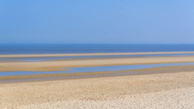 kumlu plaj sahil, mavi deniz suyu ve gökyüzü 