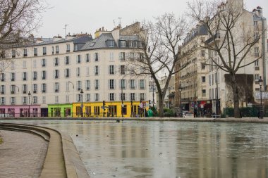     Paris, canal Saint-Martin, iskele üzerinde kanal renkli evlerin kışın donmuş 