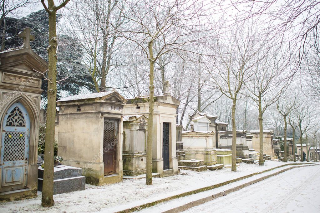 cemetery tombstones, footpath road covered with snow and trees in winter, Pere Lachaise