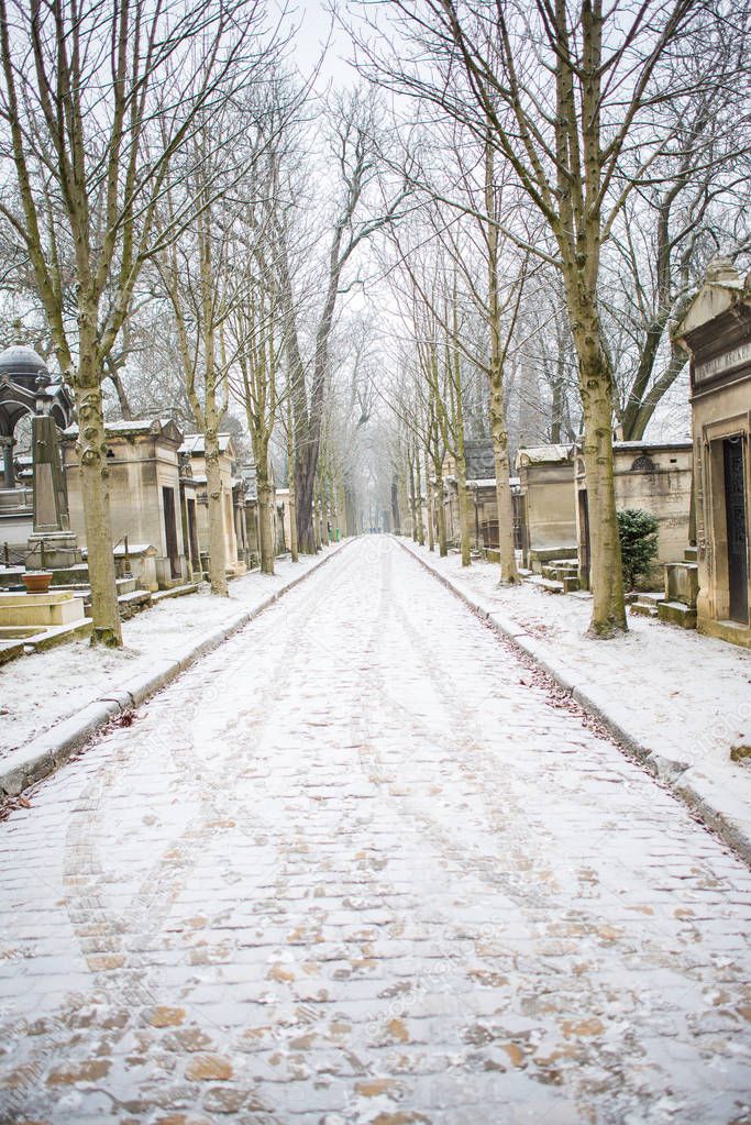 cemetery tombstones, footpath road covered with snow and trees in winter, Pere Lachaise Cemetery 