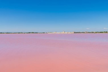     Aigues-Mortes, Salins du Midi, arka planda pembe göl ve Aigues-Mortes panorama 
