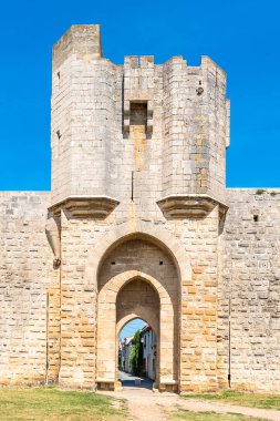 Aigues-Mortes Fransa, güneyinde şehir duvarları ile arka planda tipik bir sokak 