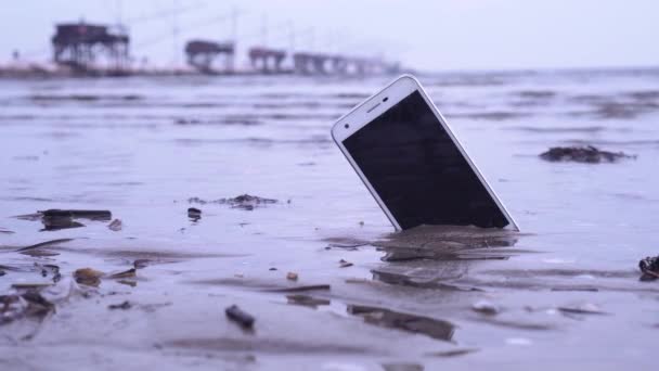 Sebuah Telepon Setengah Tersembunyi Pasir Basah Pantai — Stok Video